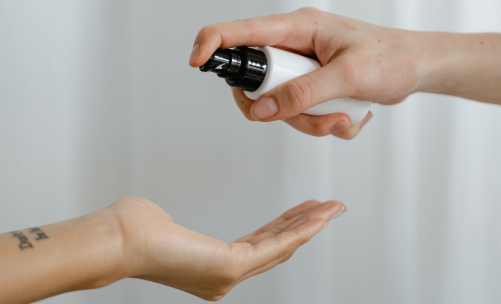 manos vertiendo agua micelar